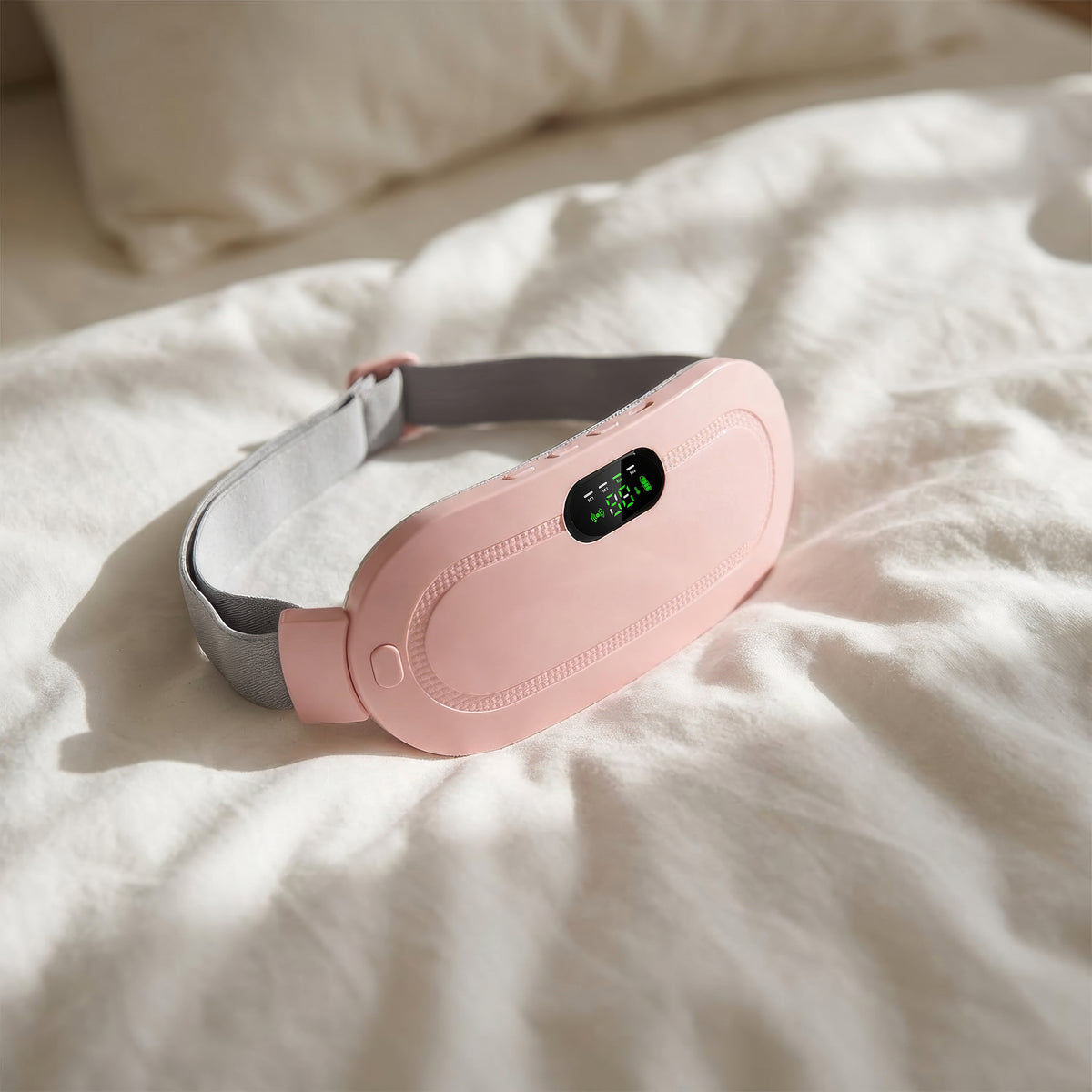 Pink and gray electronic device on a white bed